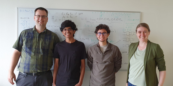 Four persons standing next to each other.